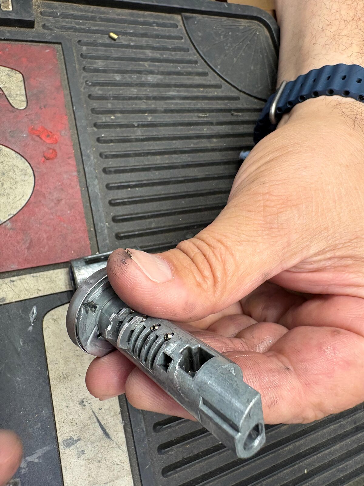 Disassembled Chevy Camaro ignition cylinder showing internal wafer slots during repair