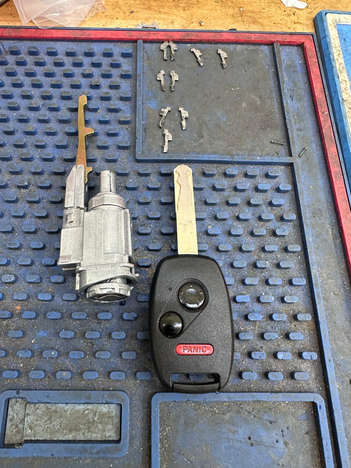 Rebuilt Honda ignition cylinder with new key and old worn wafers shown for comparison in OKC