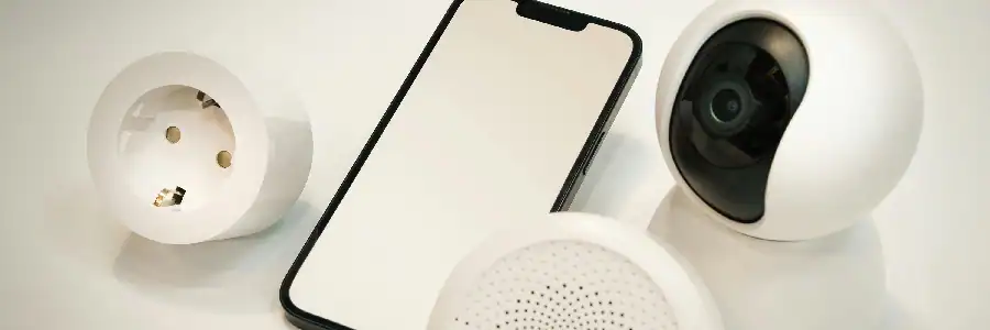 phone, indoor camera, and smoke detector against a white background