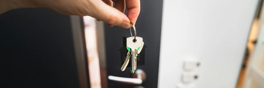 A person is holding a key to a door